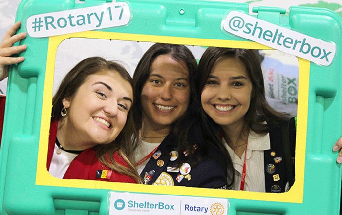 3 girls holding ShelterBox and Rotary frame