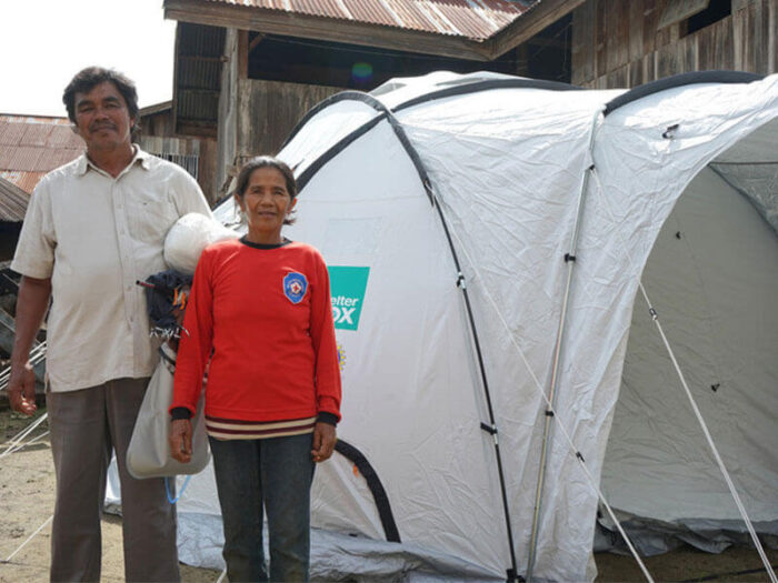 Couple standing outside a tent.