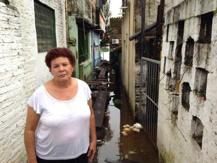 Woman stands in floodwater outside her home in Paraguay