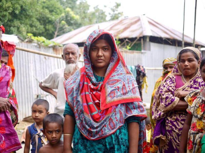 Woman in headscarf stands with community in Bangladesh