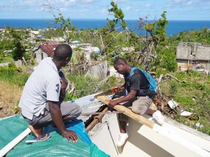 2 men rebuilding a roof in Dominica