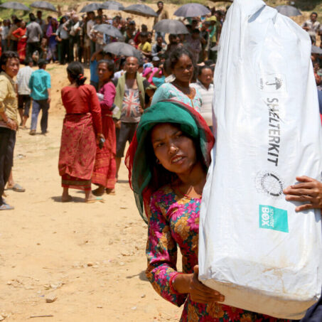 A lady carrying a Shelterbox kit in Nepal