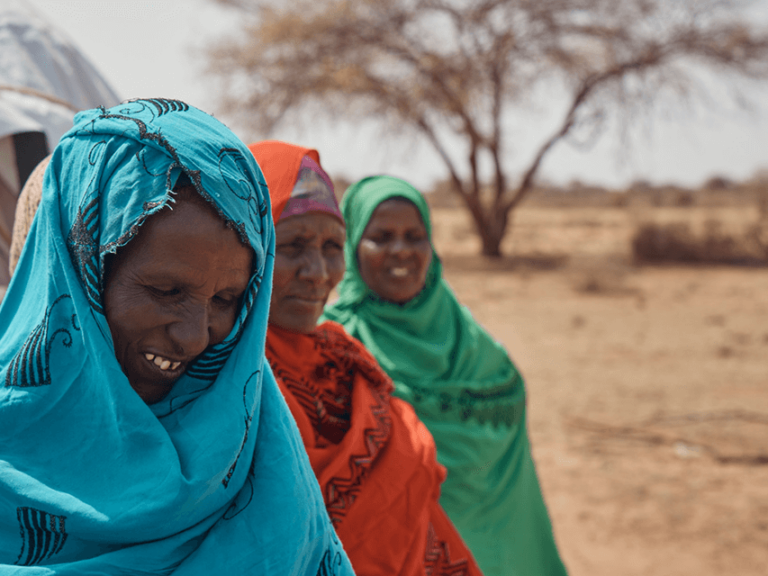 Three smiling brightly dressed Somali women