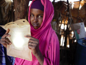 Young woman from Somaliland holds a solar light