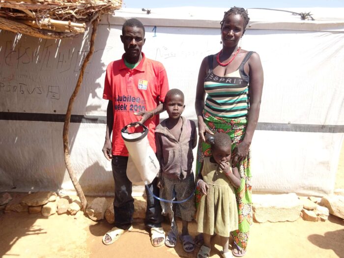 A family posing with their water filter.