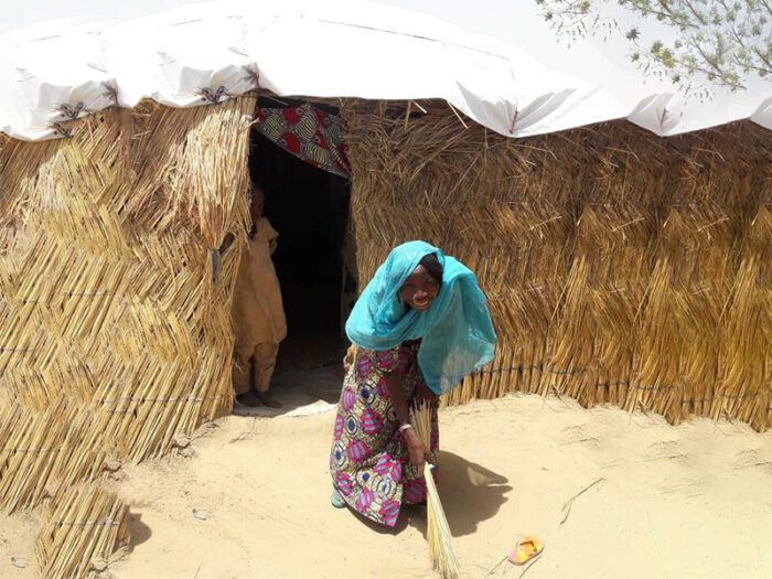 Woman outside her shelter in Nigeria