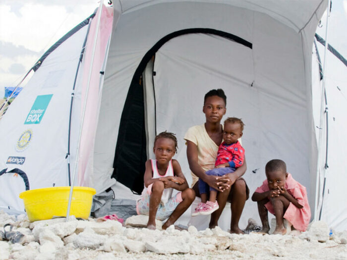 A family sits outside a ShelterBox tent after the Haiti earthquake in 2010