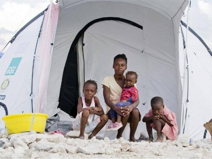 Young woman with her children outside a shelterbox home