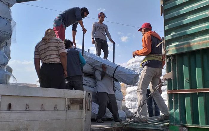 People unloading aid off a truck in Syria