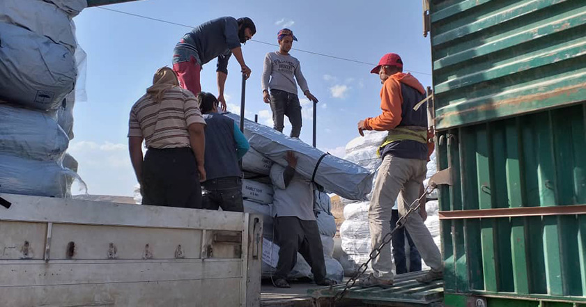 People unloading aid off a truck in Syria
