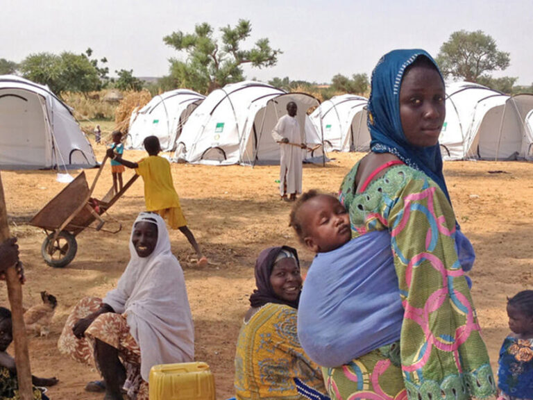 Woman with a baby in her back, in a camp in Niger