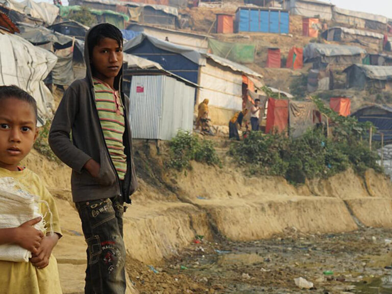 rohingya crisis children standing in front of shelters banner