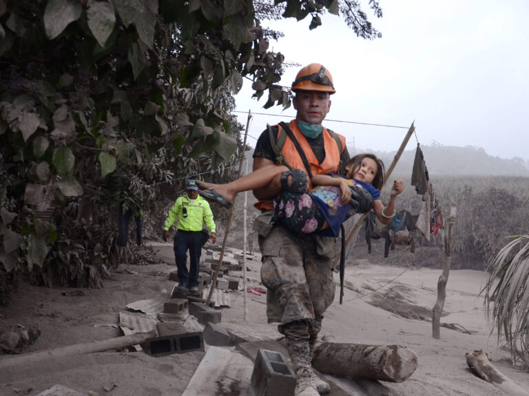 Guatemala volcano - soldier carrying child