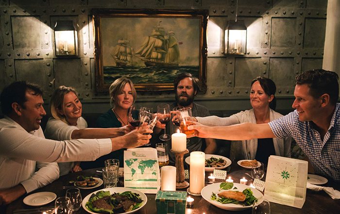 People clinking glasses above a dinner table