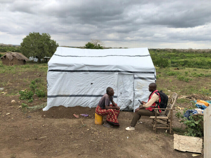 people chatting outside a shelter in Kenya