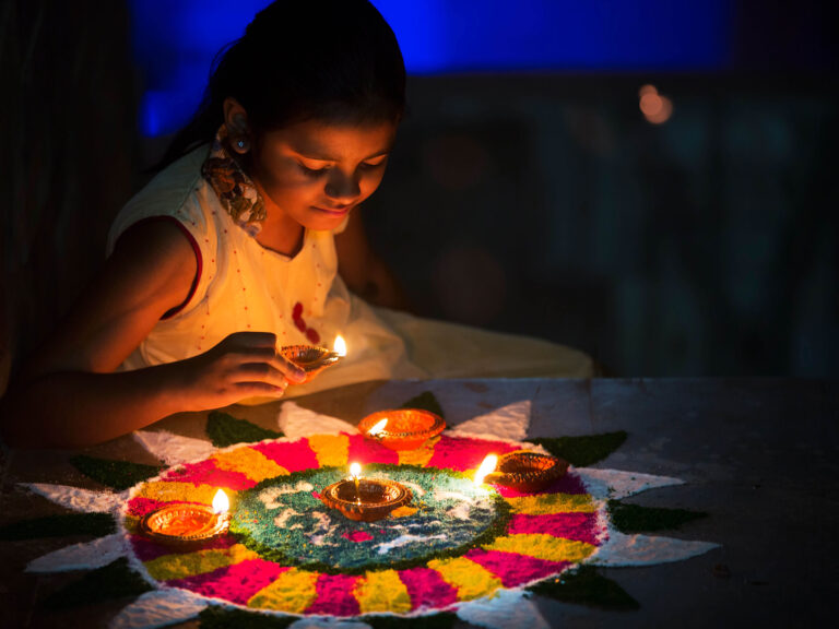 girl lighting a candle in the dark