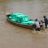 2 men pushing a boat with green shelterboxes in it