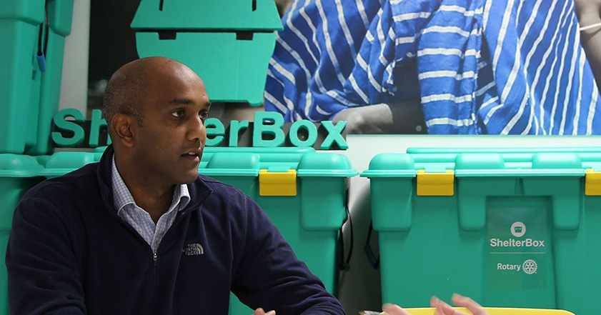 Man in front of some green boxes