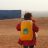 Child with their back to the camera, carrying a yellow backpack with the ShelterBox logo on it in Syria