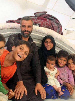 syrian family sit together in tent