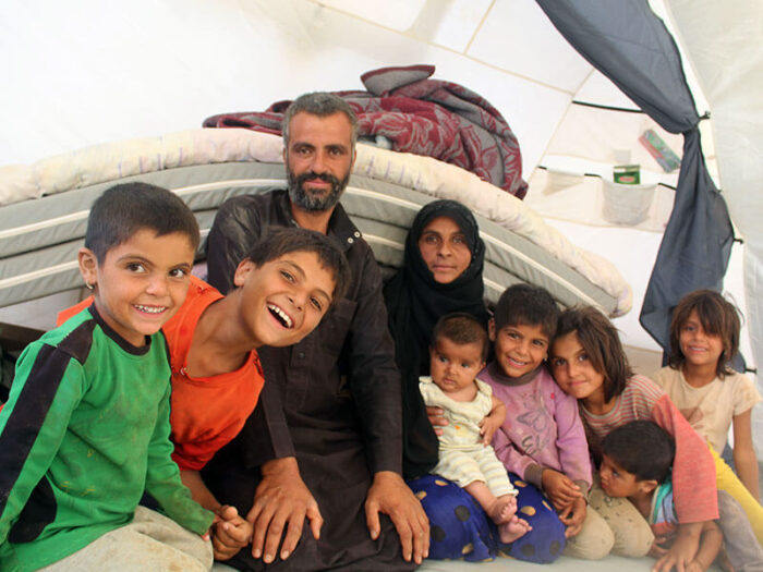 syrian family sit together in tent