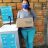 woman in facemask holds box of soap next to a washing station in Paraguay