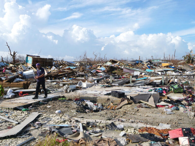 Man walks amongst widespread destruction in the Bahamas in 2019, following hurricane Dorian