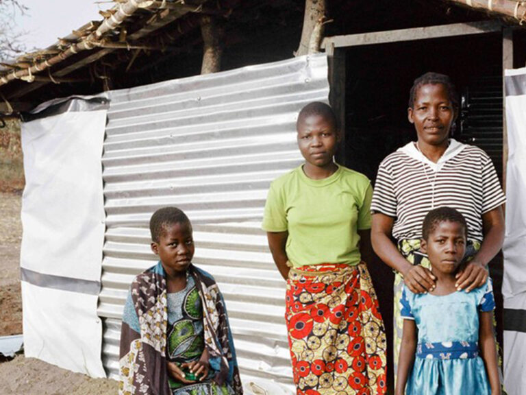 A family posing outside their home in Malawi