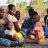 people sitting in dappled sunlight malawi