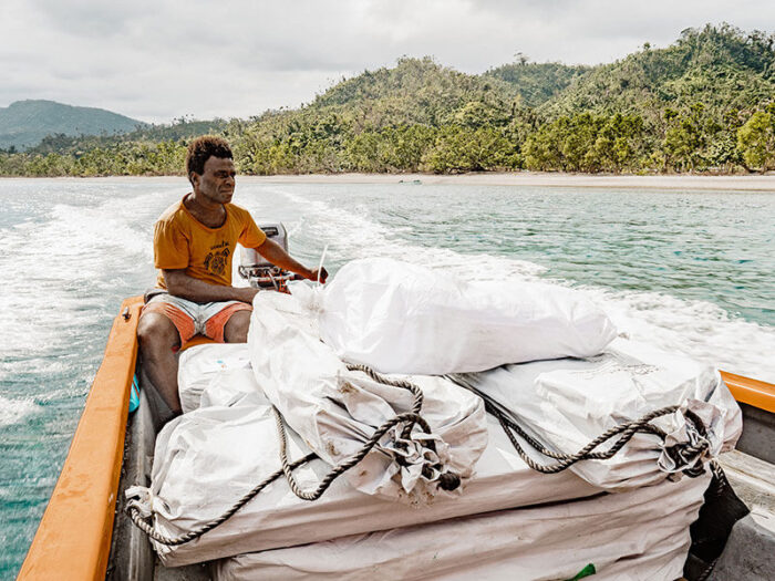 Man with bags of aid in a boat off the coast of Vanuatu
