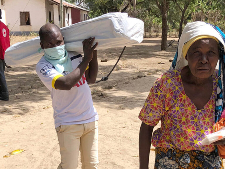 An elderly man and woman carrying their ShelterBox aid in Tanzania