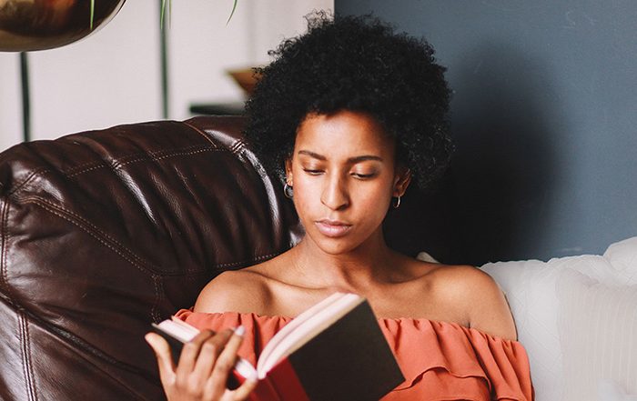 Woman sitting on sofa reading