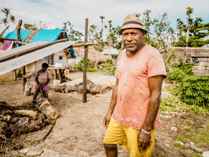 A man in Vanuatu standing around temporary shelters