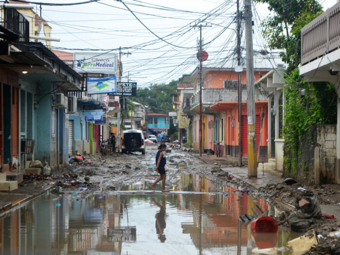 A woman walks on a flooded street in Honduras