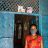 A woman wearing a medical face mask standing outside her home in India