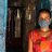 A woman wearing a medical face mask standing outside her home in India
