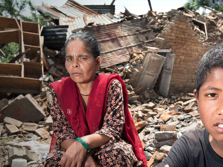 mother and son sit in rubble after nepal earthquake