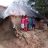 family stand in home destroyed by flooding in india