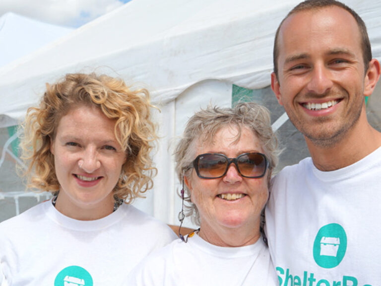 Three people in ShelterBox tshirts smiling
