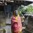 A woman wearing a face mask stands outside her home in India