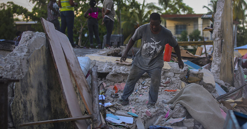 Man walking among rubble in Haiti