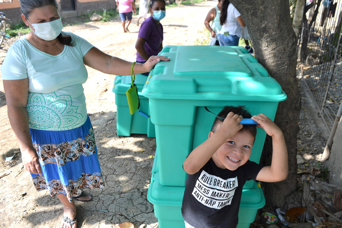 Woman and child with a large green box containing aid from ShelterBox after Hurricanes in Honduras