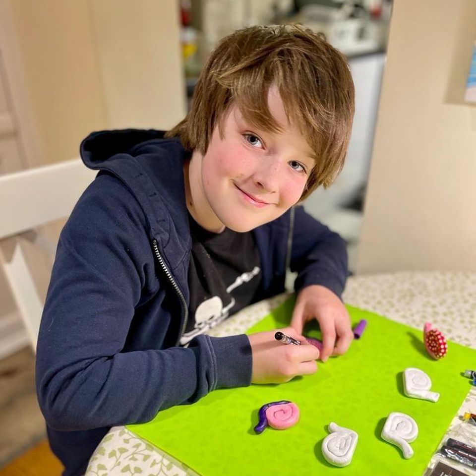 A boy making clay snails as fundraising for ShelterBox