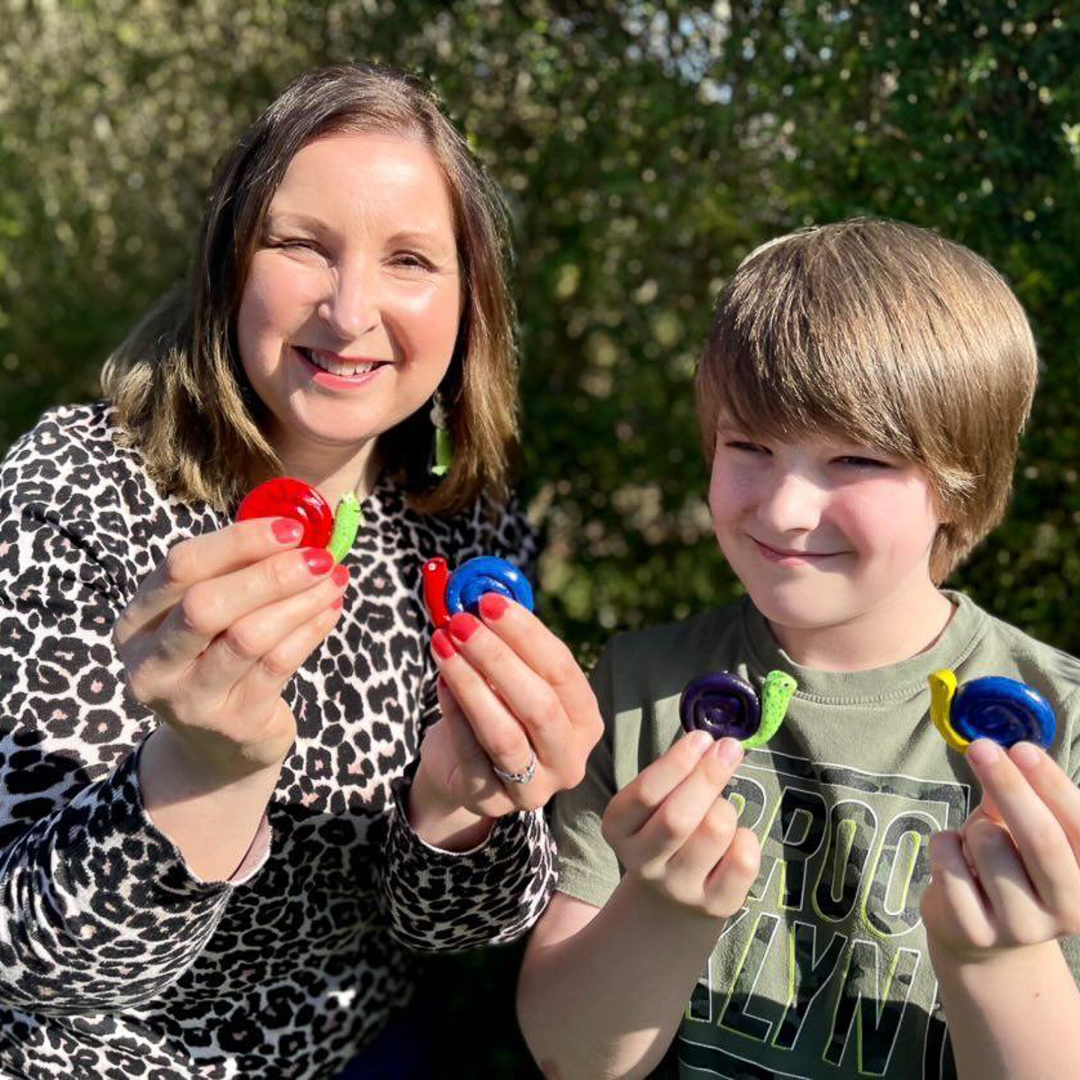 A boy and his mum holding clay snails made to fundraise for ShelterBox