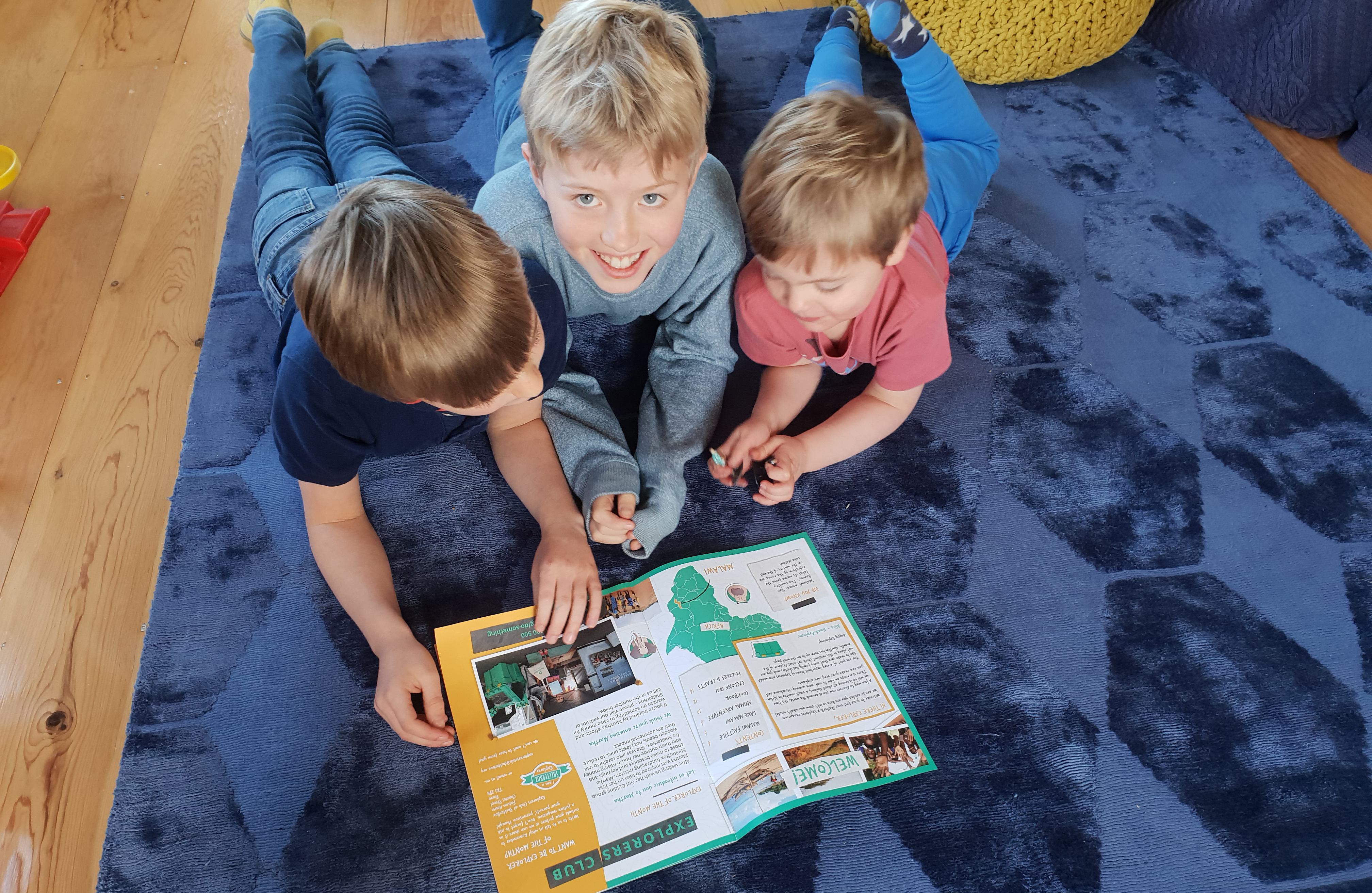 3 children looking at a ShelterBox explorers magazine