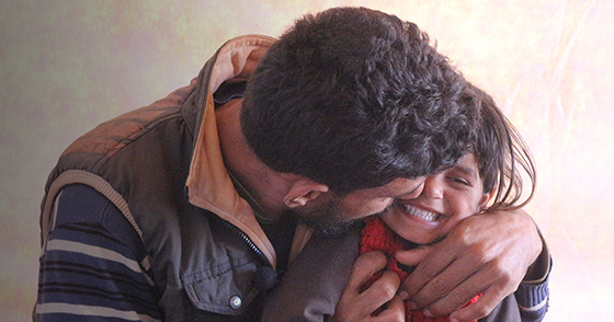 man laughing hugging daughter in Syria