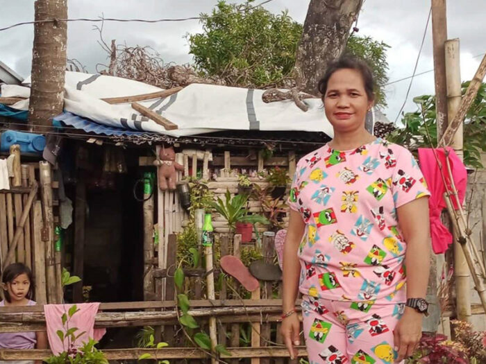 A woman wearing pink clothing standing outside her home