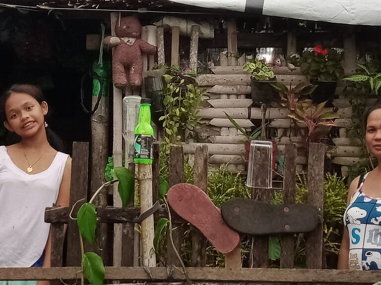 Two women outside their home