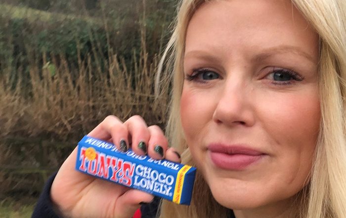 Woman with blonde hair holding a chocolate bar