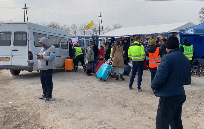 People getting off a van in Moldova with suitcases after fleeing Ukraine